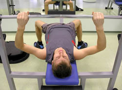 Model performing a bench press exercise