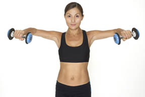Model performs the contracting section of a standing dumbbell lateral raise