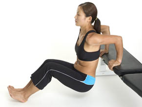 Model performing the contracting portion of the triceps dips exercise